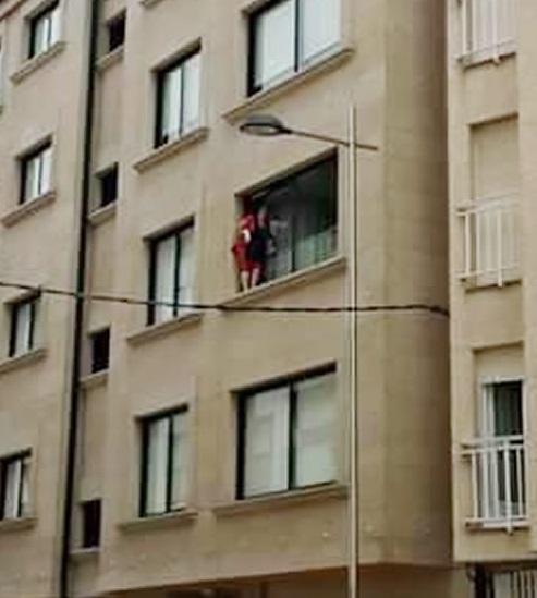 Mujer limpiando ventanas por fuera en peligro